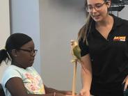 Caleigh Belyue is assisting with Phoenix the bird